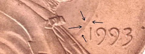 1993 Lincoln cent with die clash marks (arrows by the photographer)